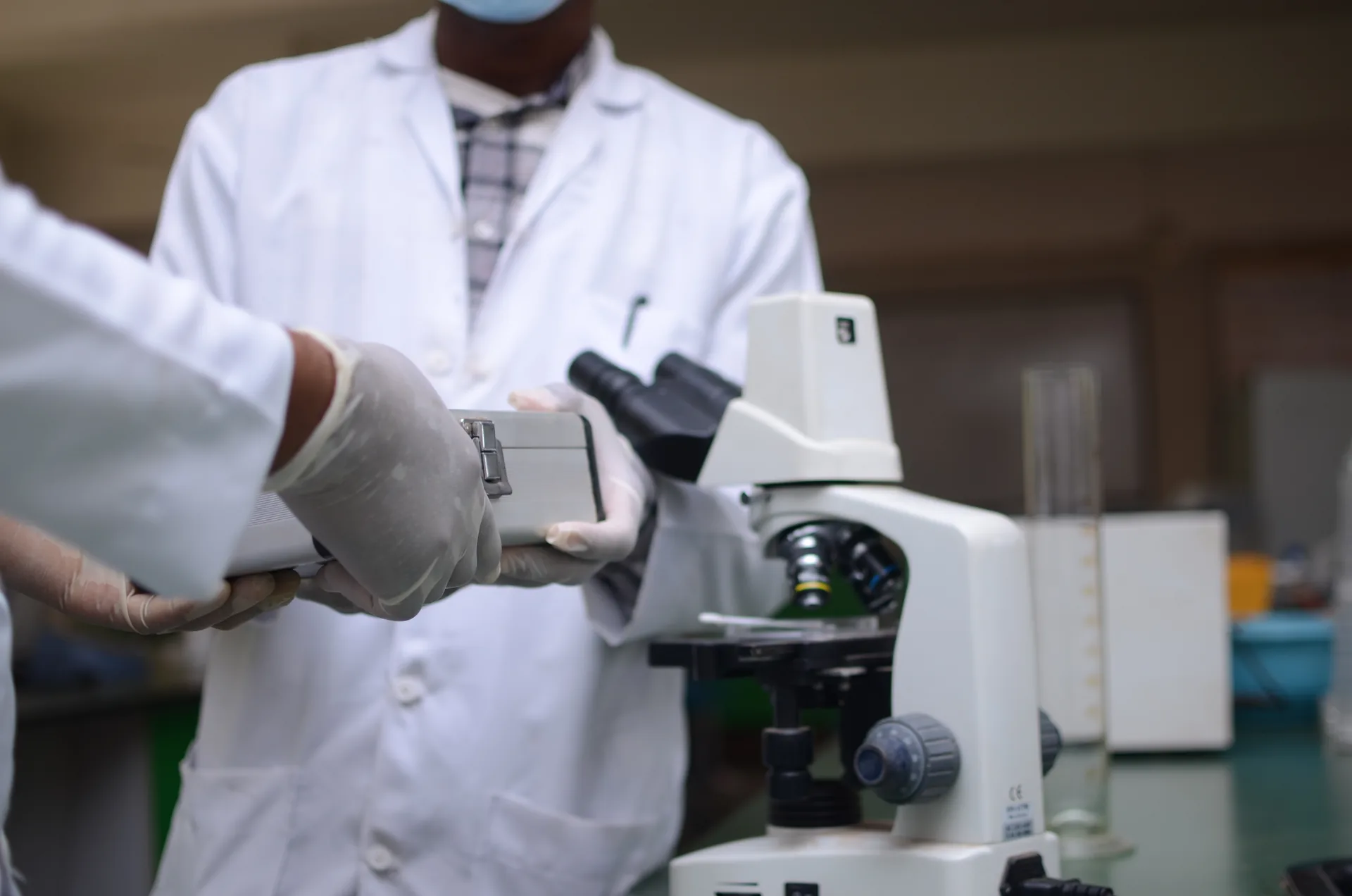 Profesionales de laboratorio con microscopio y equipo de calibración