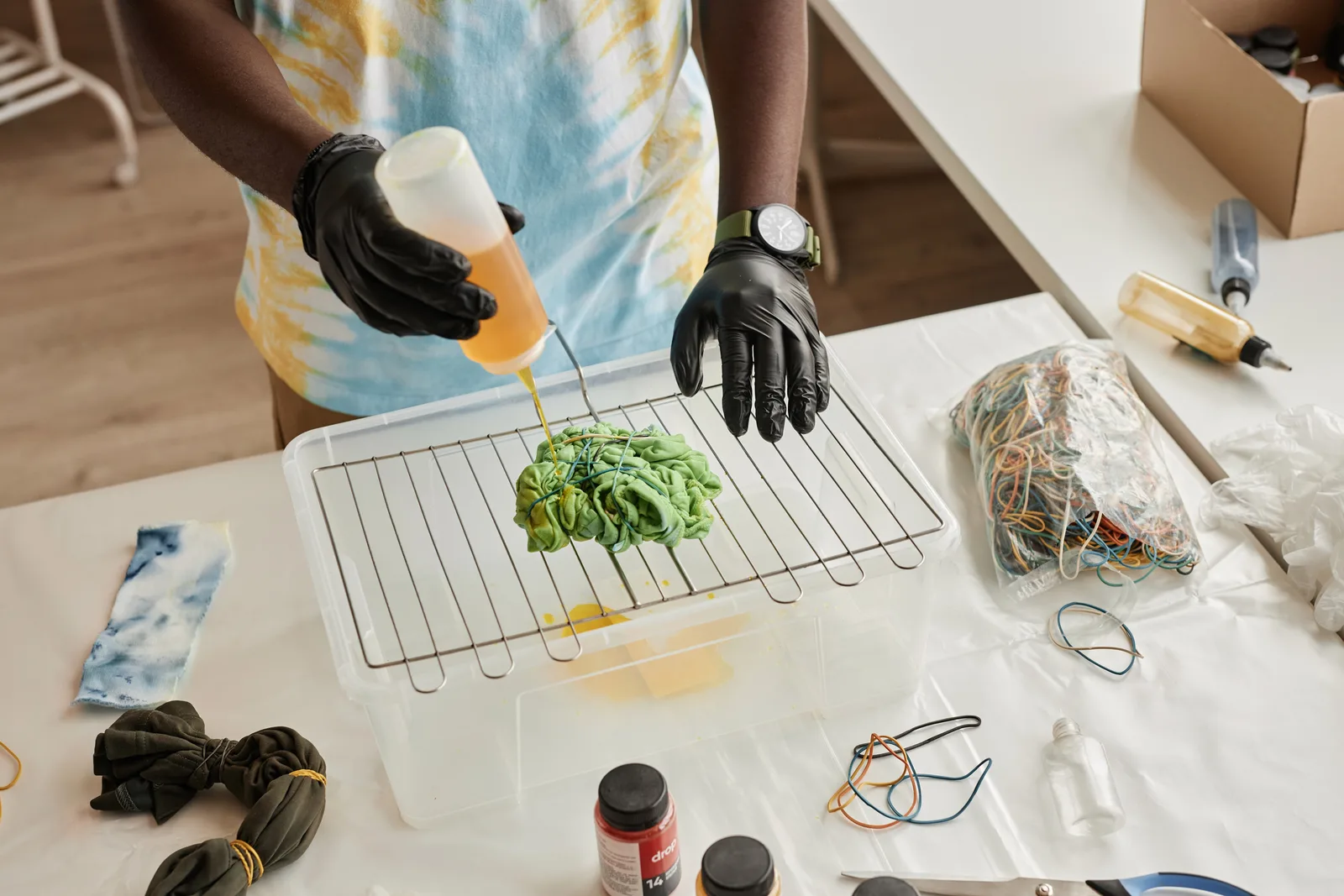 Persona con guantes aplicando tinte a una prenda